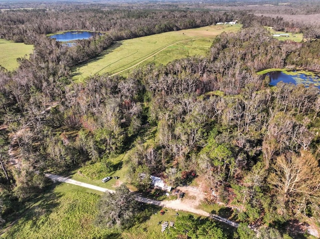 aerial view with a water view and a wooded view