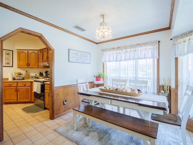 181 NE Biltmore Rd, Madison, FL 32340 - dining room featuring wainscoting, healthy amount of natural light, a chandelier, light tile patterned floors, and crown molding