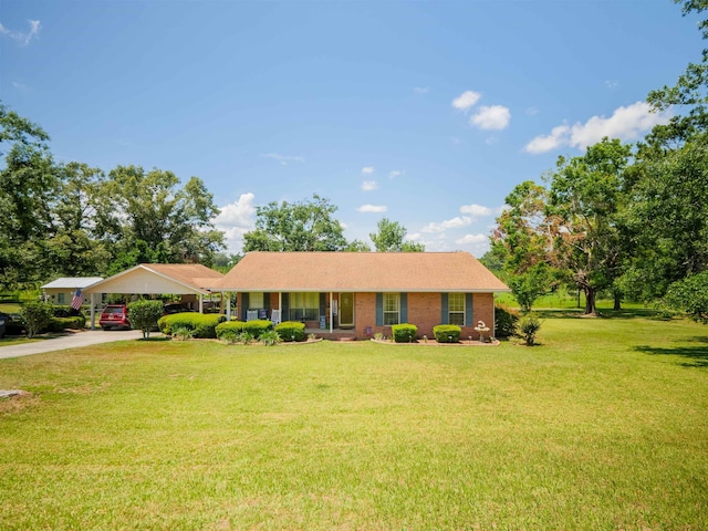 181 NE Biltmore Rd, Madison, FL 32340 - single story home with a front lawn, a carport, concrete driveway, and brick siding