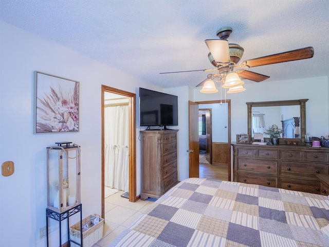 181 NE Biltmore Rd, Madison, FL 32340 - bedroom featuring a ceiling fan, a wainscoted wall, and a textured ceiling