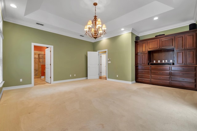 unfurnished bedroom featuring crown molding, an inviting chandelier, ensuite bath, a raised ceiling, and light colored carpet