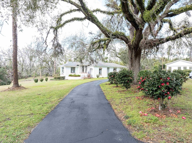 ranch-style house with aphalt driveway and a front yard