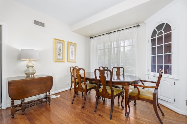 dining room with wood finished floors, visible vents, and baseboards