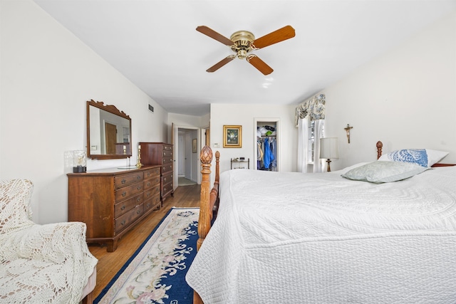 bedroom with a spacious closet, a closet, wood finished floors, and visible vents