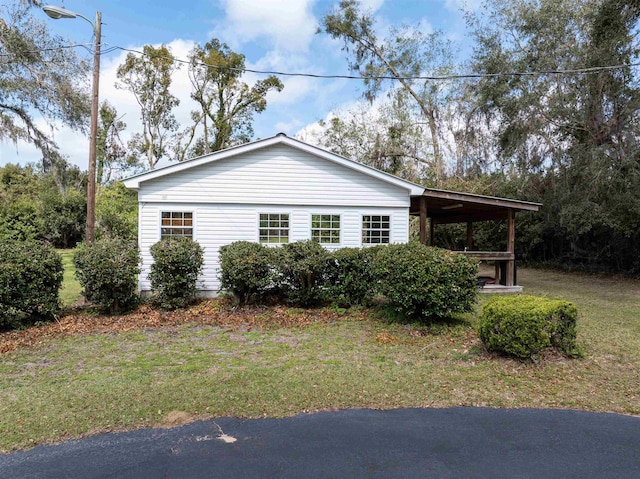 view of home's exterior featuring a carport and a lawn