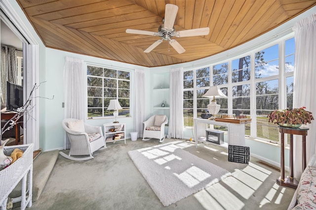 sunroom / solarium with plenty of natural light, ceiling fan, wooden ceiling, and visible vents