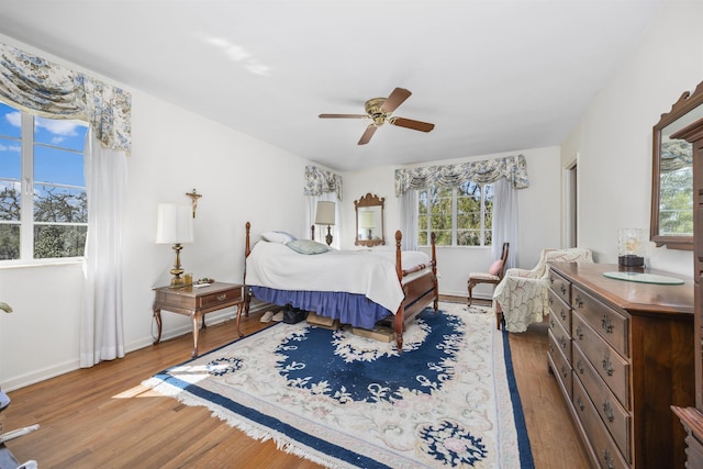 bedroom with wood finished floors, a ceiling fan, and baseboards