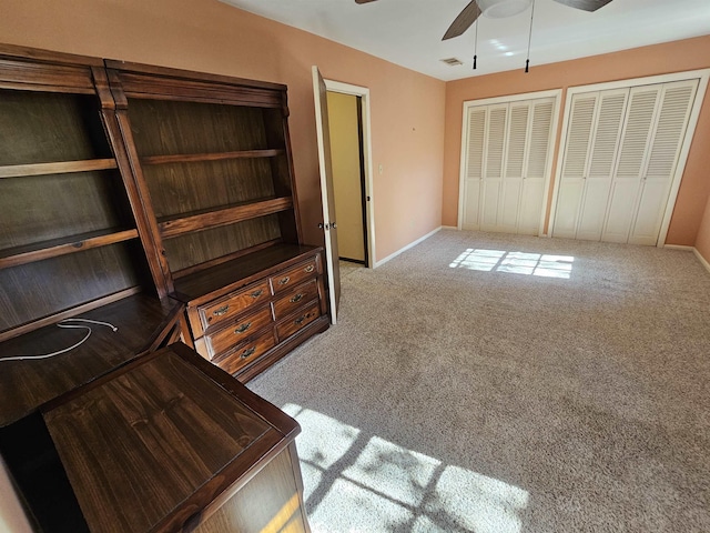 unfurnished bedroom featuring light carpet, baseboards, visible vents, and a ceiling fan