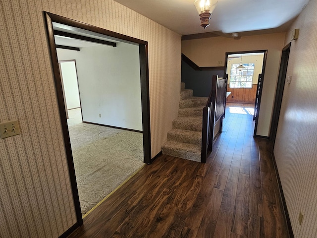 hallway featuring stairs, baseboards, dark wood finished floors, and wallpapered walls