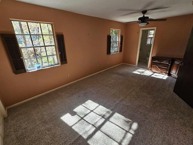 unfurnished living room featuring plenty of natural light, carpet flooring, and baseboards