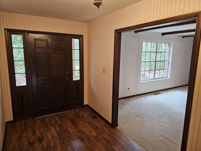 foyer featuring baseboards and wallpapered walls