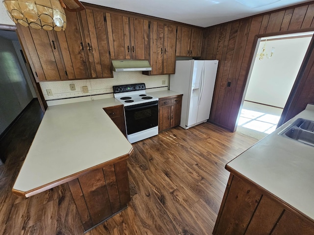 kitchen featuring range with electric cooktop, dark wood finished floors, light countertops, under cabinet range hood, and white fridge with ice dispenser