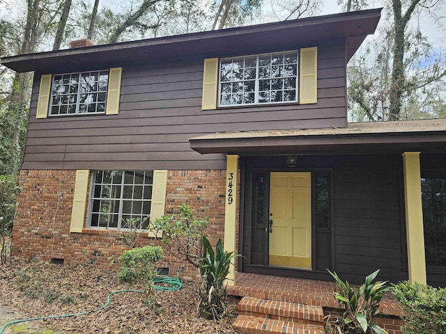 view of front of property featuring entry steps, brick siding, and crawl space