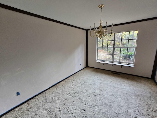 spare room with ornamental molding, light colored carpet, baseboards, and an inviting chandelier