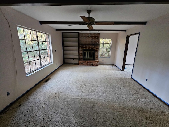 unfurnished living room featuring beam ceiling, light carpet, a fireplace, and baseboards