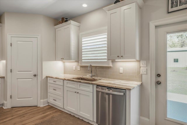 kitchen with backsplash, a sink, white cabinets, and stainless steel dishwasher