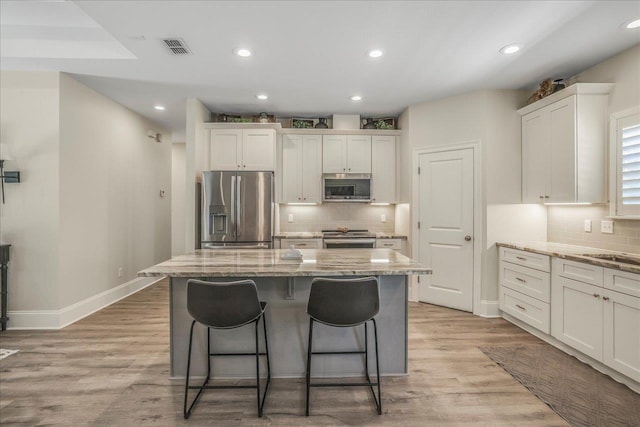 kitchen featuring light wood finished floors, visible vents, white cabinets, and appliances with stainless steel finishes