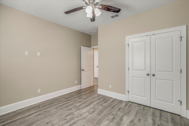 unfurnished bedroom with visible vents, a ceiling fan, a closet, light wood-style floors, and baseboards