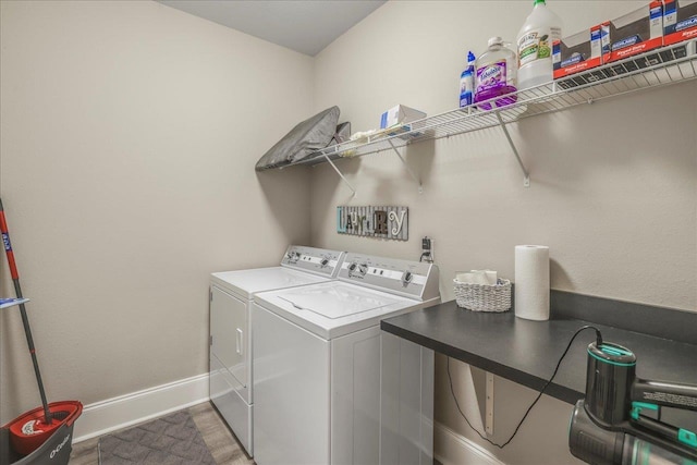 laundry area featuring washer and clothes dryer, laundry area, baseboards, and wood finished floors