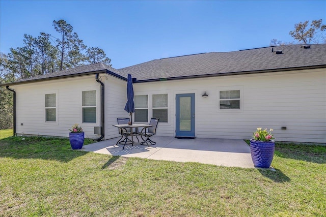 back of house with a patio area, a lawn, and roof with shingles