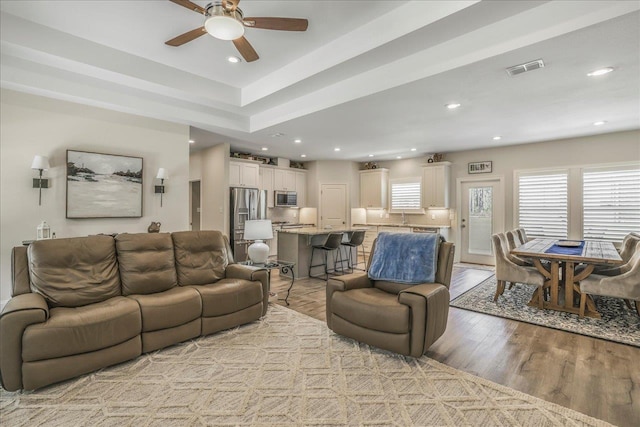 living room with a ceiling fan, recessed lighting, visible vents, and light wood-type flooring