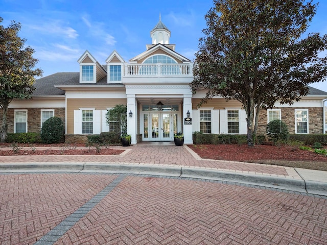 view of front facade with a balcony and french doors