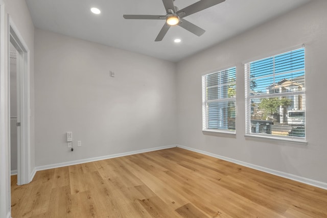 empty room featuring plenty of natural light, ceiling fan, and light hardwood / wood-style flooring