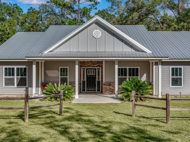 back of property featuring covered porch and a lawn