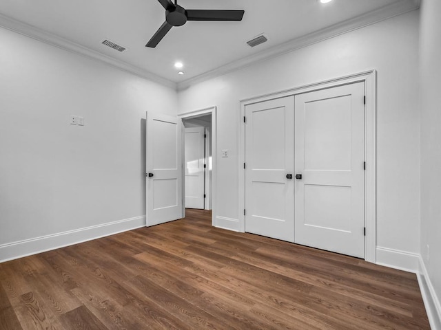 unfurnished bedroom with ceiling fan, dark hardwood / wood-style floors, a closet, and crown molding