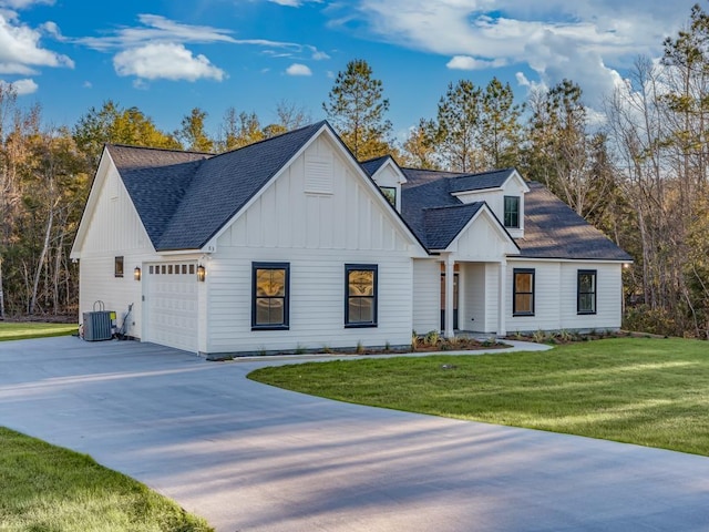 modern farmhouse with central AC unit, a front lawn, and a garage