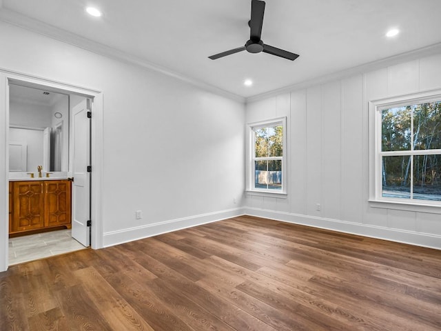 unfurnished bedroom with ensuite bathroom, ceiling fan, crown molding, and hardwood / wood-style floors