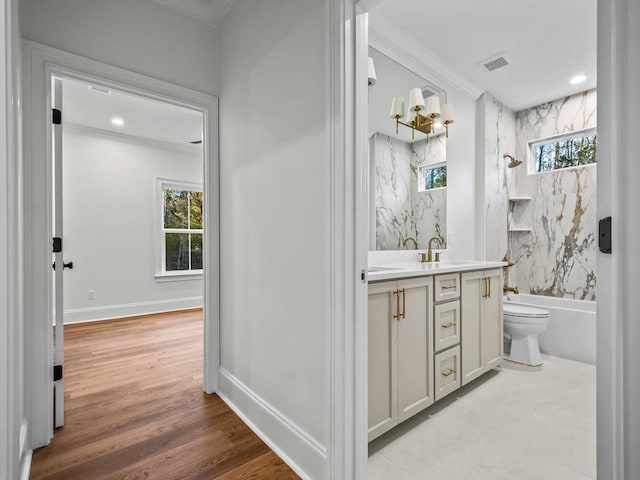 full bathroom featuring toilet, a healthy amount of sunlight, vanity, and bathtub / shower combination