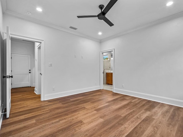 empty room featuring ceiling fan, crown molding, and hardwood / wood-style flooring