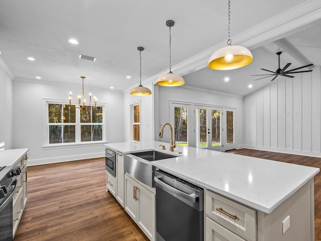 kitchen with sink, white cabinetry, hanging light fixtures, a kitchen island with sink, and appliances with stainless steel finishes