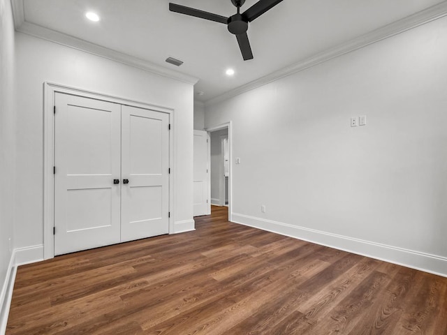 unfurnished bedroom with ceiling fan, dark hardwood / wood-style flooring, a closet, and ornamental molding