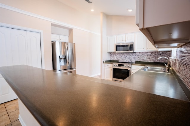 9321 Royal Troon Dr, Tallahassee, FL 32312 - kitchen with appliances with stainless steel finishes, a sink, dark countertops, tasteful backsplash, and a peninsula