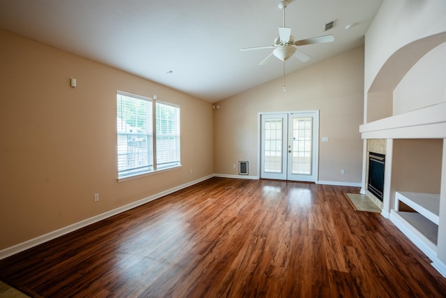 9321 Royal Troon Dr, Tallahassee, FL 32312 - unfurnished living room featuring ceiling fan, dark wood-style flooring, a tiled fireplace, baseboards, and high vaulted ceiling