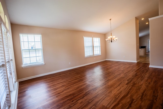 9321 Royal Troon Dr, Tallahassee, FL 32312 - spare room with a chandelier, baseboards, dark wood-style floors, and vaulted ceiling
