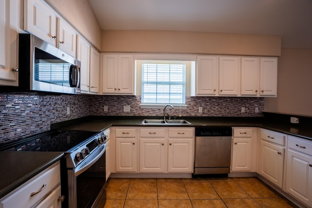 9321 Royal Troon Dr, Tallahassee, FL 32312 - kitchen featuring appliances with stainless steel finishes, a sink, dark countertops, light tile patterned floors, and white cabinetry
