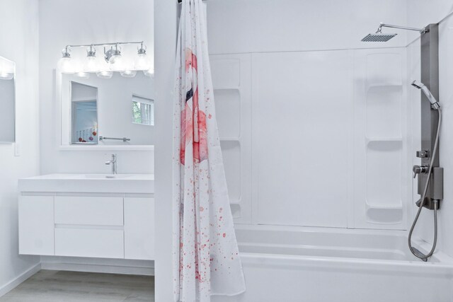 bathroom featuring wood-type flooring, shower / bath combo with shower curtain, and vanity