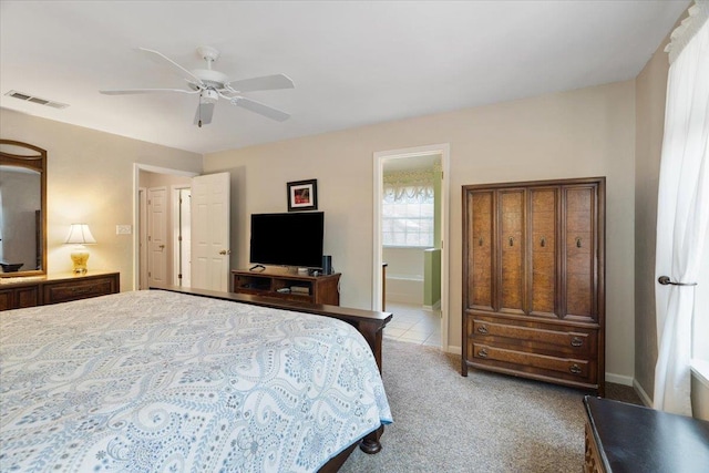 carpeted bedroom with baseboards, visible vents, ceiling fan, and ensuite bathroom