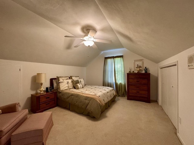 bedroom with a ceiling fan, vaulted ceiling, and light colored carpet