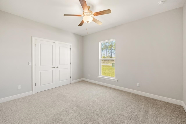 unfurnished bedroom with carpet flooring, a closet, and ceiling fan