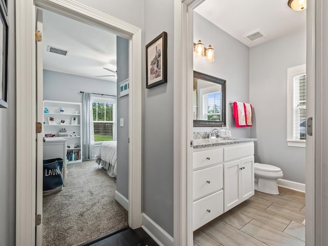 bathroom featuring hardwood / wood-style floors, vanity, ceiling fan, and toilet