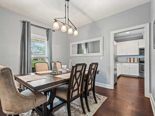 dining space with dark hardwood / wood-style flooring, an inviting chandelier, and ornamental molding