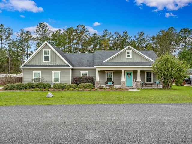 craftsman house featuring covered porch and a front yard