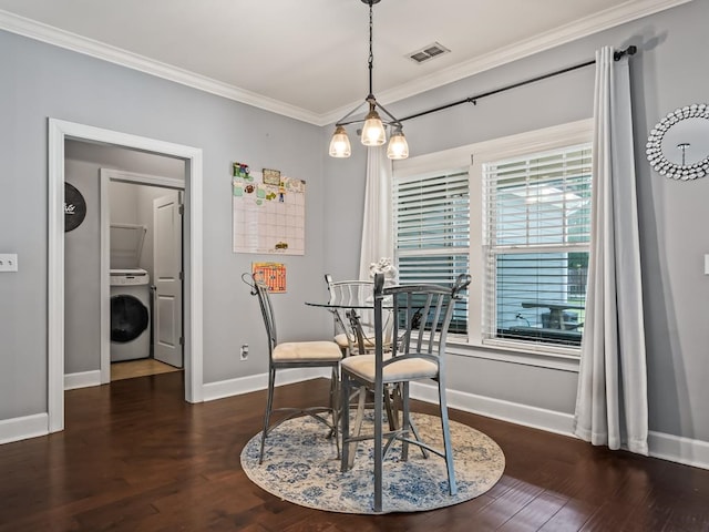 dining area featuring dark hardwood / wood-style floors, washer / dryer, and crown molding