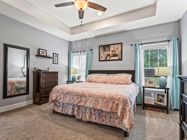 bedroom featuring a tray ceiling, ceiling fan, and carpet