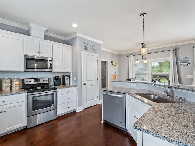 kitchen with decorative light fixtures, white cabinetry, sink, and appliances with stainless steel finishes