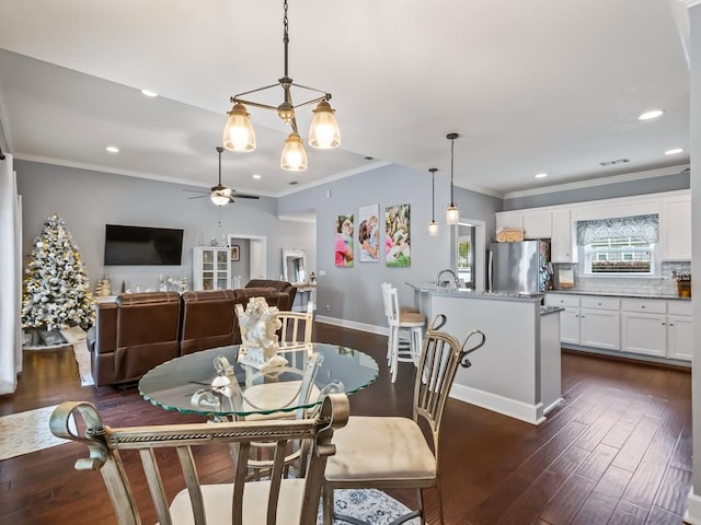 dining room featuring crown molding, ceiling fan, and dark wood-type flooring